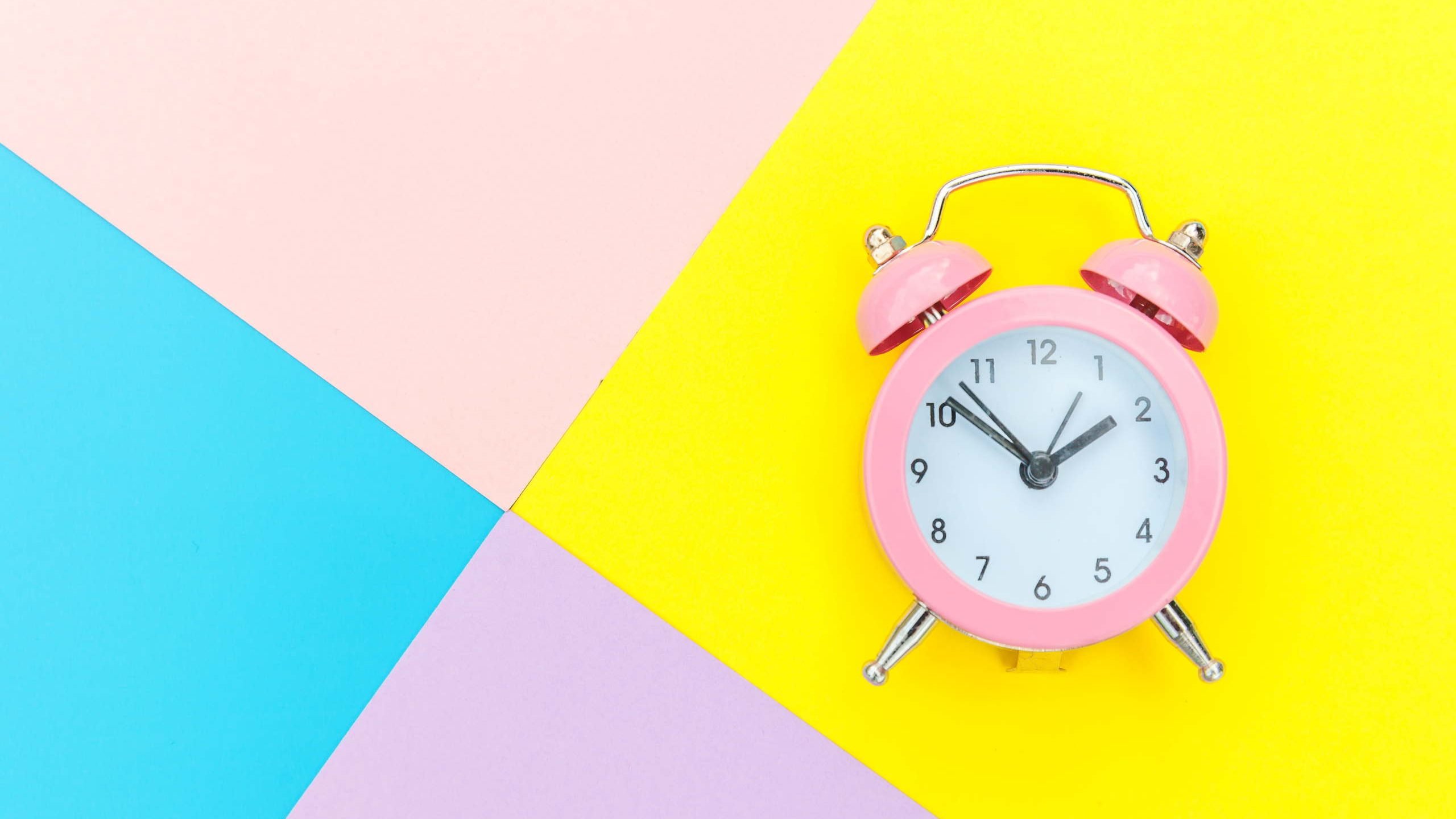 Cómo se dice la hora en inglés reloj rosa sobre fondo de colores