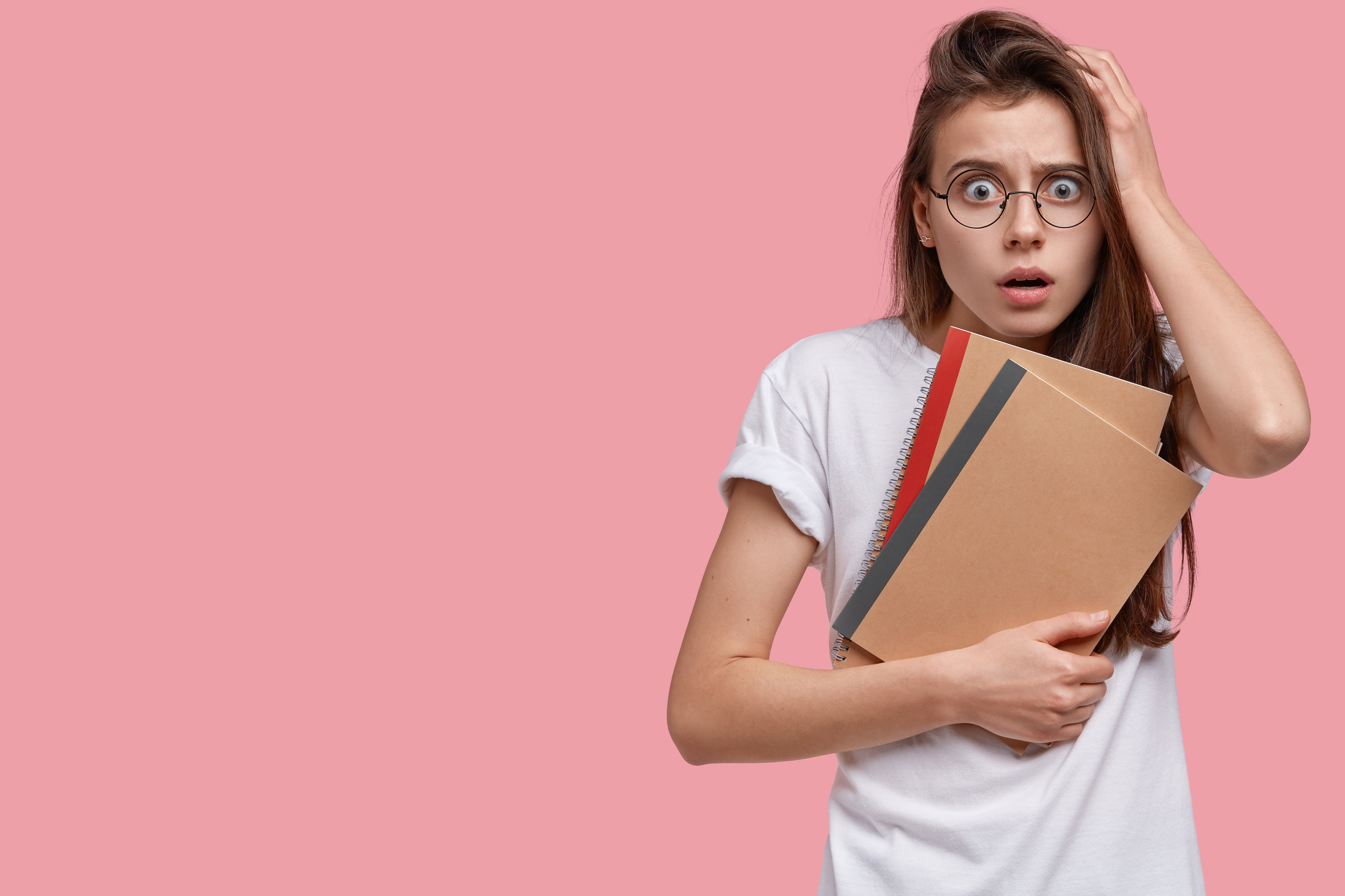 chica sujetando libros mientras se sorprende